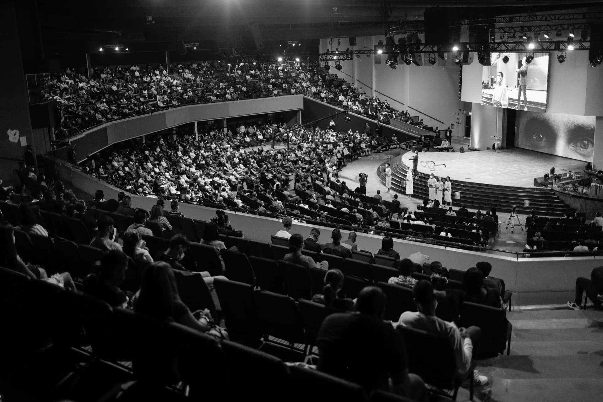 A full auditorium listening to a speaker
